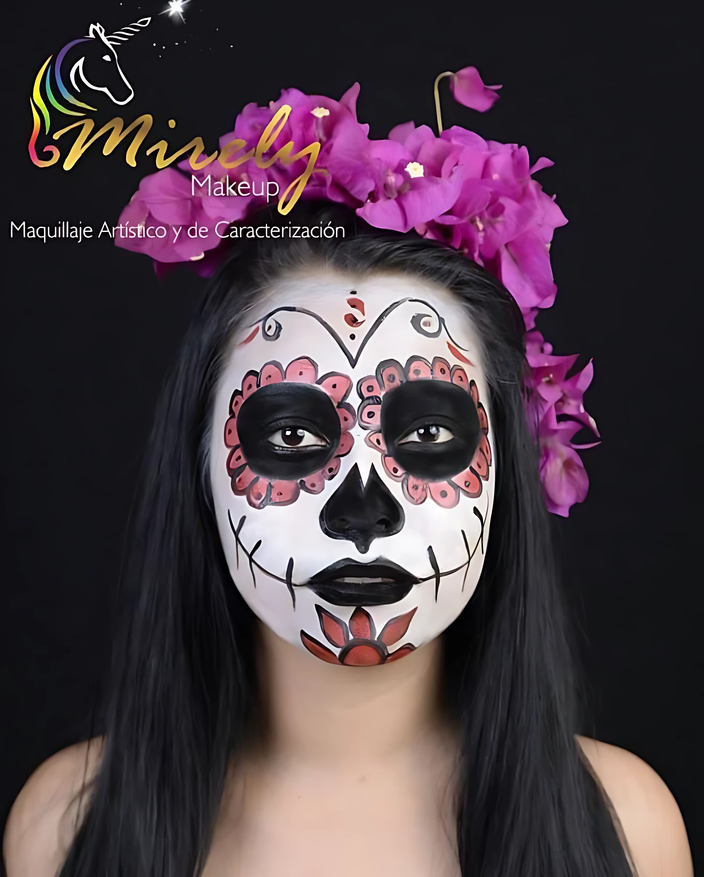 Modelo con maquillaje artístico estilo calavera de Día de Muertos, diseño facial detallado en blanco, negro y rosa, con flores magenta en la cabeza.