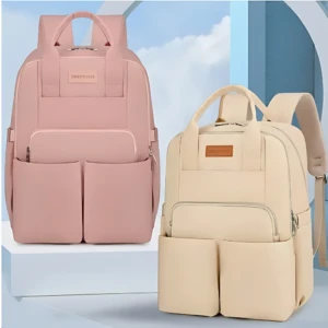 Pañalera Oxford en rosa y beige, con compartimentos frontales y asas superiores, ideal para organizar equipaje de bebé.