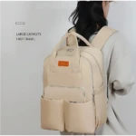 Pañalera Oxford color crema con compartimentos térmicos, vista trasera de modelo usando la mochila.