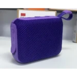 Parlante Bluetooth portátil en color morado con textura de malla, diseño compacto y asa integrada para transporte.