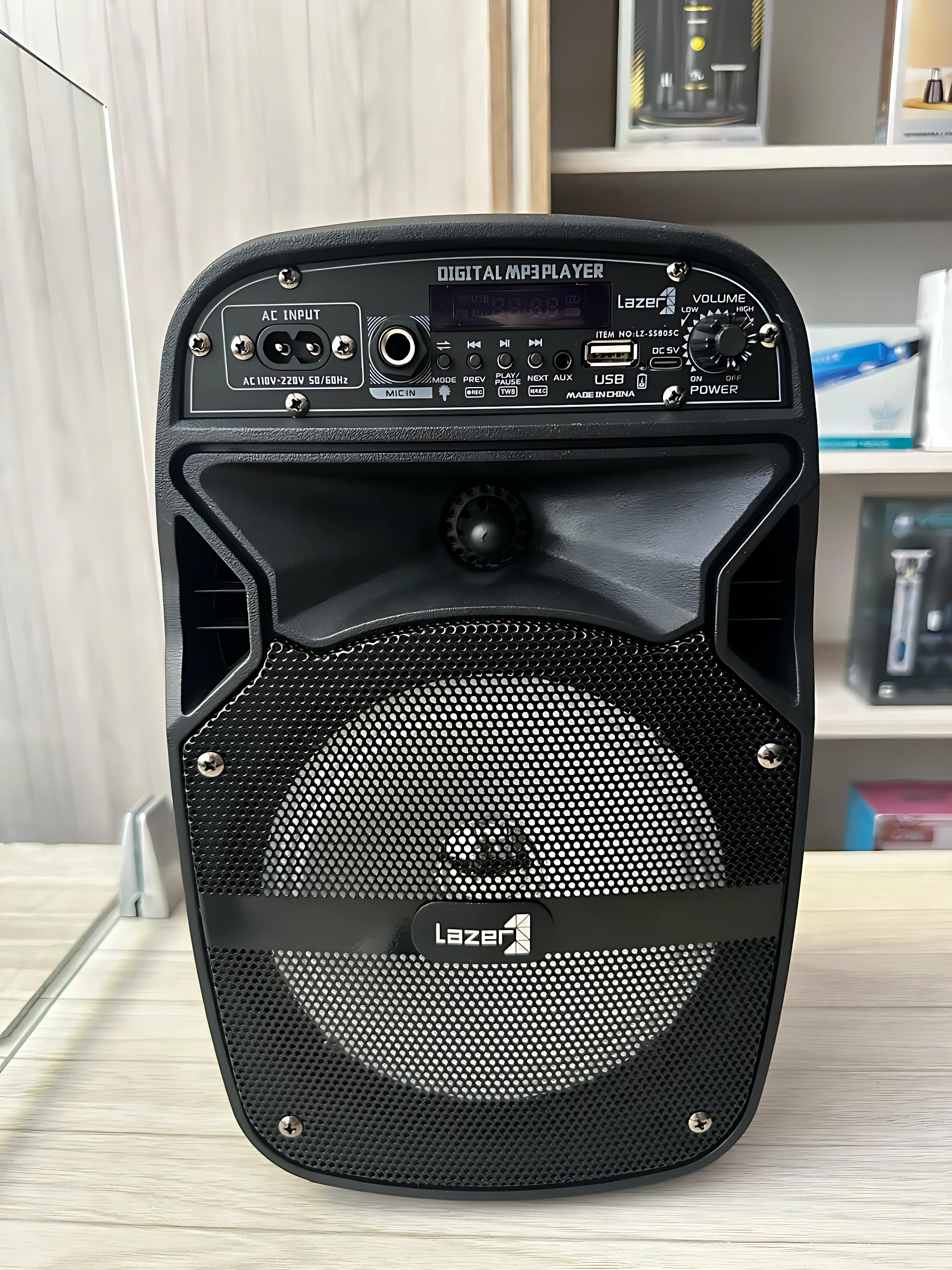Parlante Lz 805 negro con panel de control frontal, rejilla circular y logo visible. Incluye micrófono integrado y luces LED.