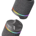 Parlante Bluetooth M25 en color gris con tela texturizada y anillo de luces RGB multicolor en la base, mostrando vista frontal y superior.