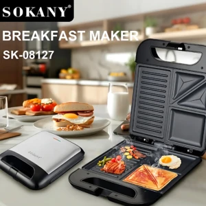 Sanduchera Sokany SK-08122 abierta mostrando placas antiadherentes con sándwich, huevo y carne; junto a ella, la tapa cerrada y platos con desayuno en cocina moderna.