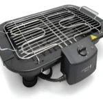 Parrillera eléctrica compacta de color negro con rejilla metálica y panel de control lateral, diseñada para uso en espacios reducidos.