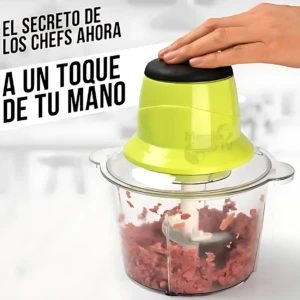 Picatodo eléctrico de 300W con base transparente y tapa verde lima, procesando carne molida; mano presionando el botón superior.