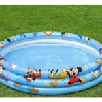 Piscina inflable azul con Mickey Mouse y amigos, vista superior sobre césped verde.