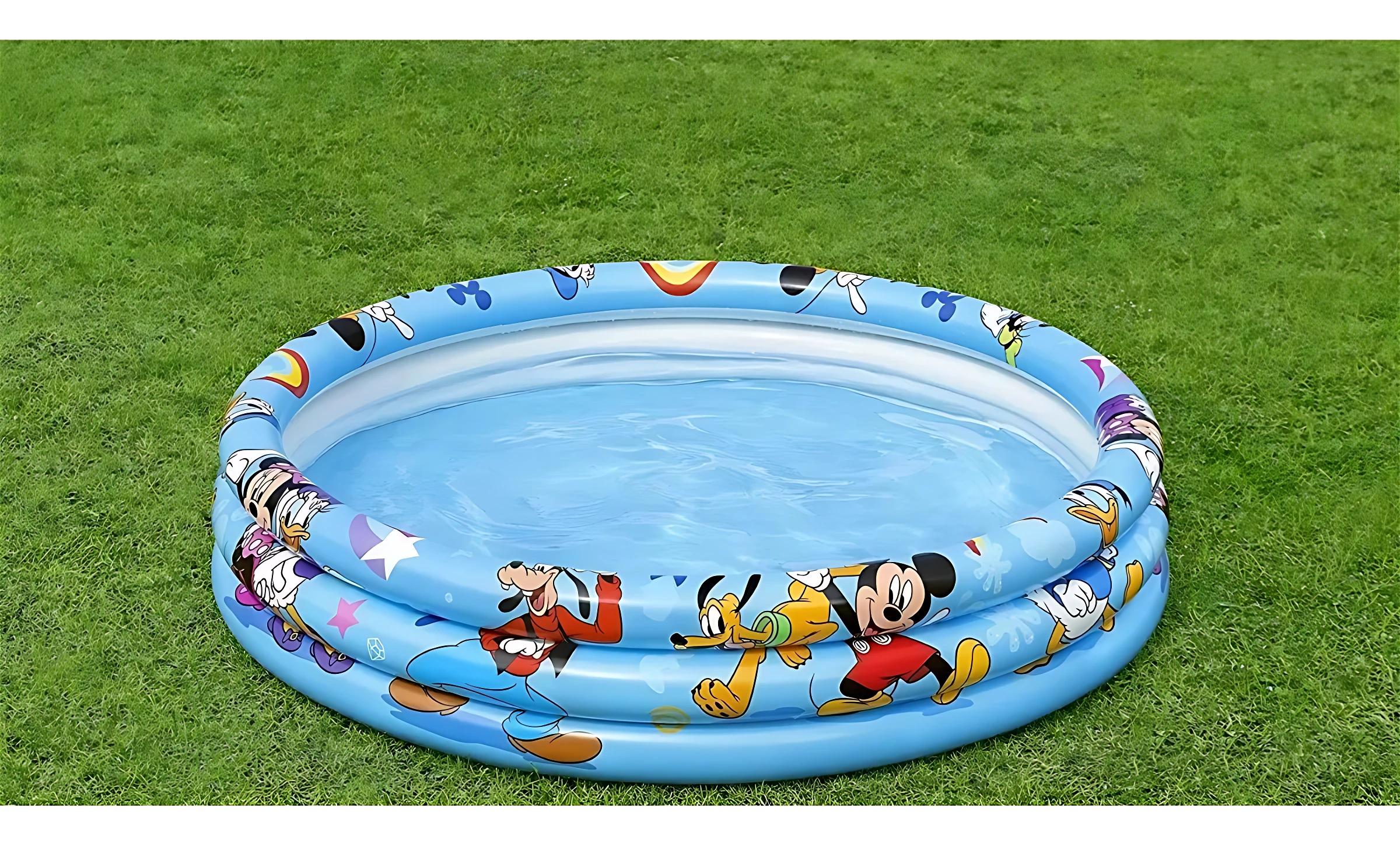 Piscina inflable azul con Mickey Mouse y amigos, vista superior sobre césped verde.