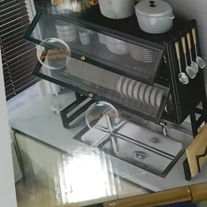 Escurridor de vajilla doble tapa en metal negro con estantes para platos y utensilios, instalado sobre fregadero de acero inoxidable.