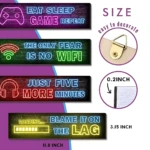 Cuatro posters decorativos de madera con estética neón para gamers, mostrando frases como 'Eat Sleep Game Repeat' y 'The Only Fear Is No Wifi', con medidas de 11.8 pulgadas de ancho y 3.15 pulgadas de alto.