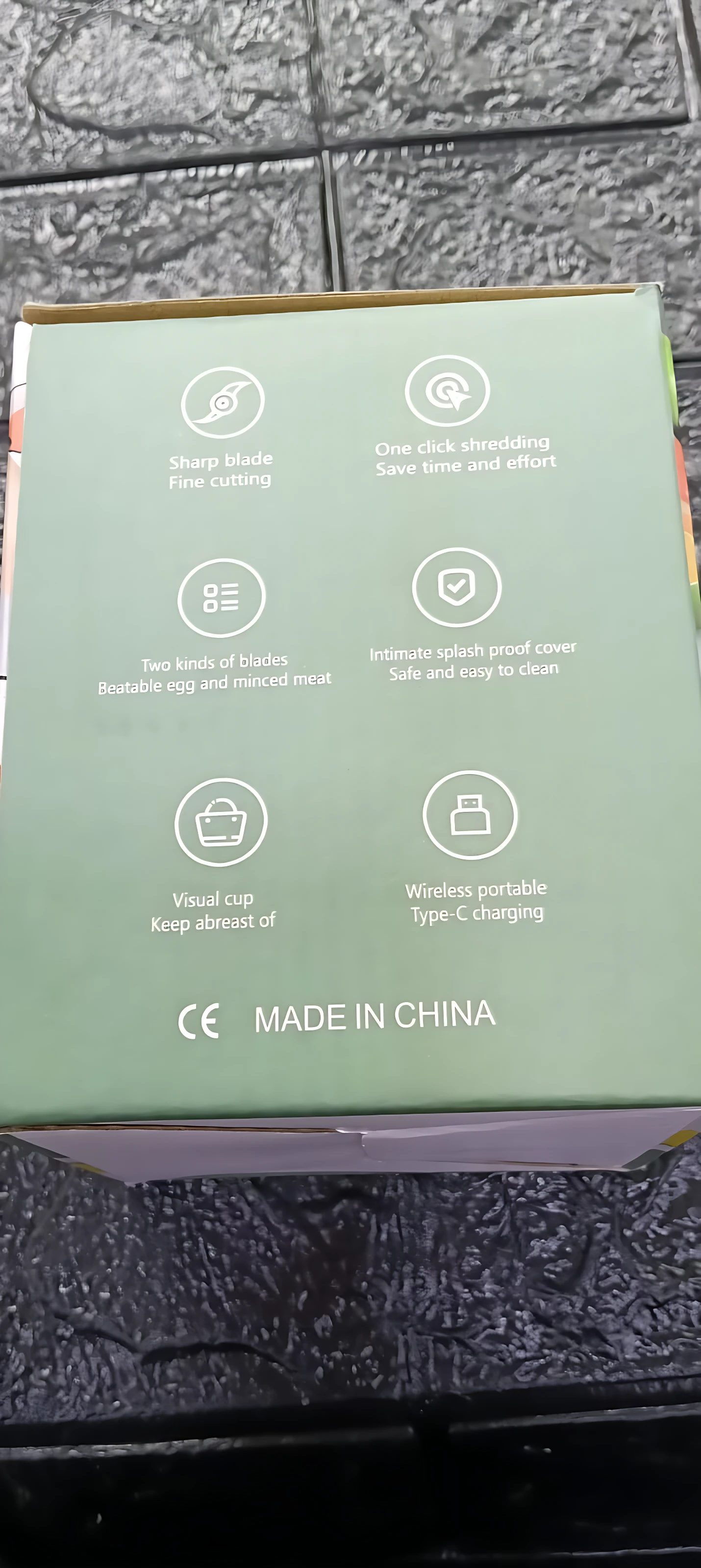 Caja verde del procesador de alimentos portátil inalámbrico, mostrando iconos de funciones como corte fino, limpieza fácil y carga tipo C.