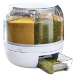 Dispensador giratorio blanco con seis compartimentos transparentes, mostrando granos como lentejas, arroz y semillas, con dispensador extraíble en la parte inferior.