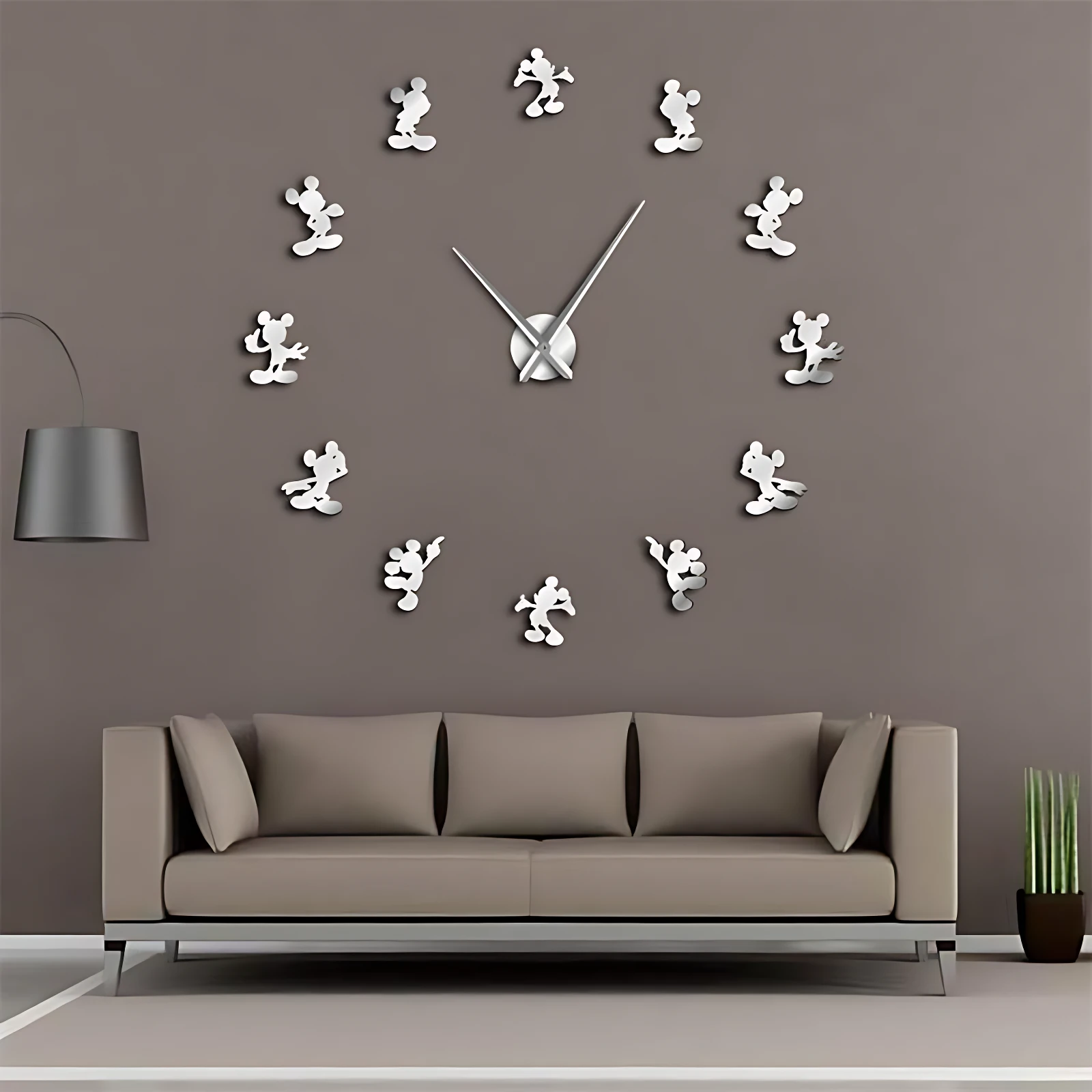 Reloj de pared con figuras de Mickey Mouse en acrílico reflectante, montado sobre sofá beige en sala moderna.