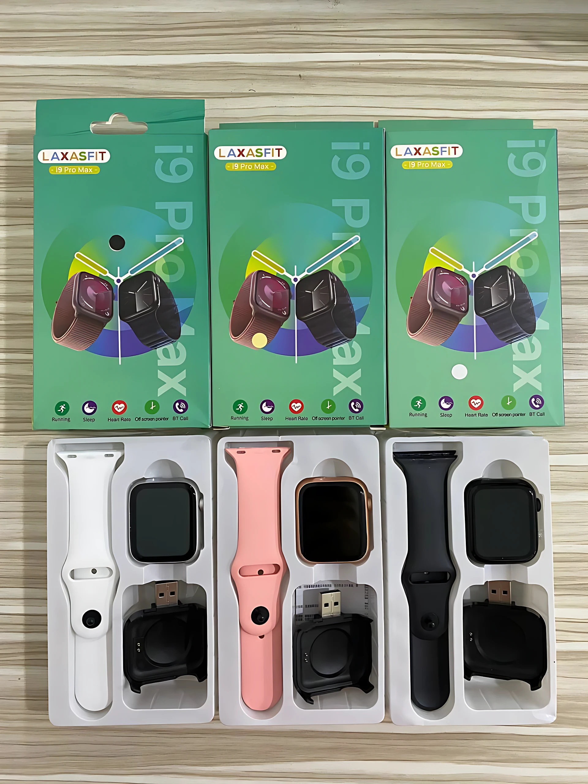 Tres cajas de reloj inteligente I9 Pro Max en colores blanco, rosa y negro, mostrando contenido del paquete con correa, cargador y accesorios.