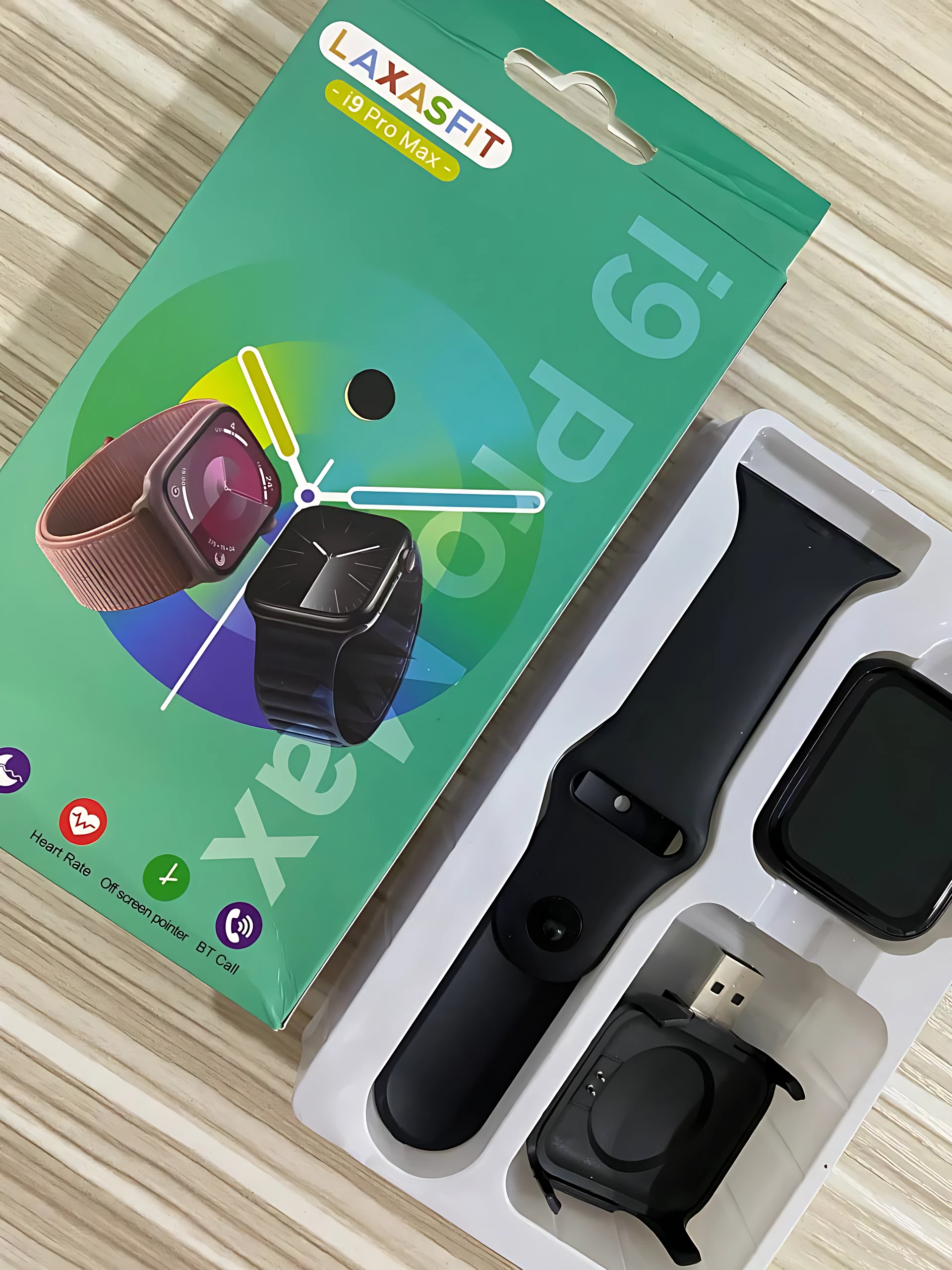 Packaging del reloj inteligente I9 Pro Max en color verde, mostrando caja con de pulsera marrón y negra, junto a correa negra, pantalla y cargador USB.