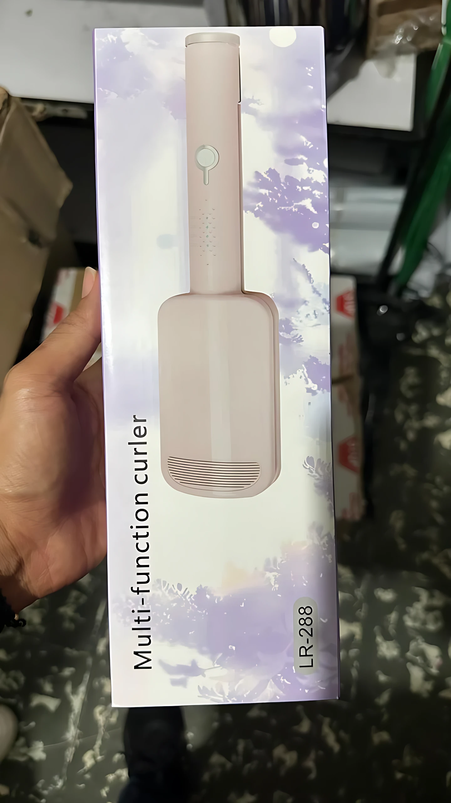 Rizador portátil compacto LR-288 en caja, color rosa pálido, con diseño ergonómico y acabado mate.