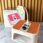 Lámpara LED UV SUNBT-12 con base naranja texturizada y panel de control digital, junto a su caja original. Ideal para secado rápido de esmaltes y pedicura.