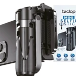 Selfie stick trípode portátil negro Teclop, con control remoto Bluetooth y soporte para iPhone, mostrando detalles de su estructura plegable y accesorios incluidos.