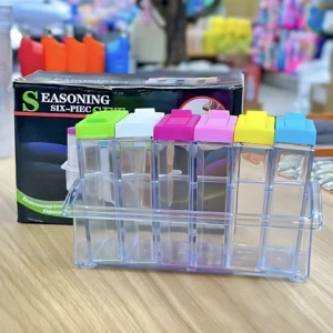 Organizador de especias transparente con seis compartimentos, tapa de colores y caja de presentación visible.