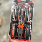 Set de cuatro herramientas de precisión con mango negro y naranja, incluyendo destornilladores y alicates, en empaque transparente con fondo blanco.