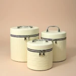 Set de tres neceseres circulares en color crema con textura de cuero, cierres metálicos y asas ergonómicas, ideales para organizar maquillaje y accesorios de viaje.