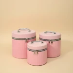 Set de tres neceseres circulares en rosa con textura de diamante, asas metálicas y cierre magnético. Ideales para maquillaje y viajes.