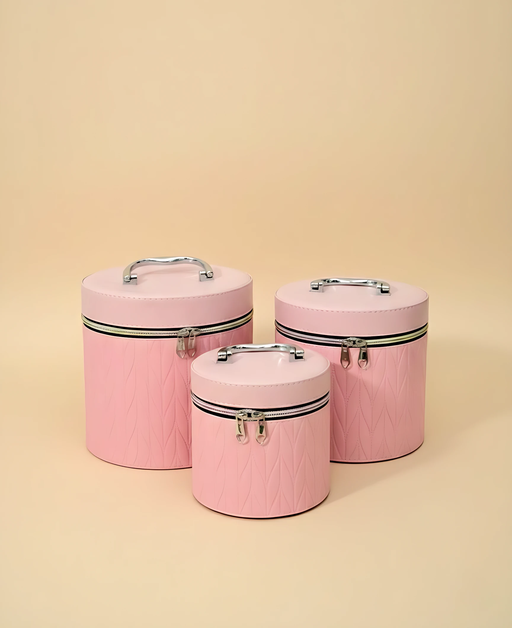 Set de tres neceseres circulares en rosa con textura de diamante, asas metálicas y cierre magnético. Ideales para maquillaje y viajes.
