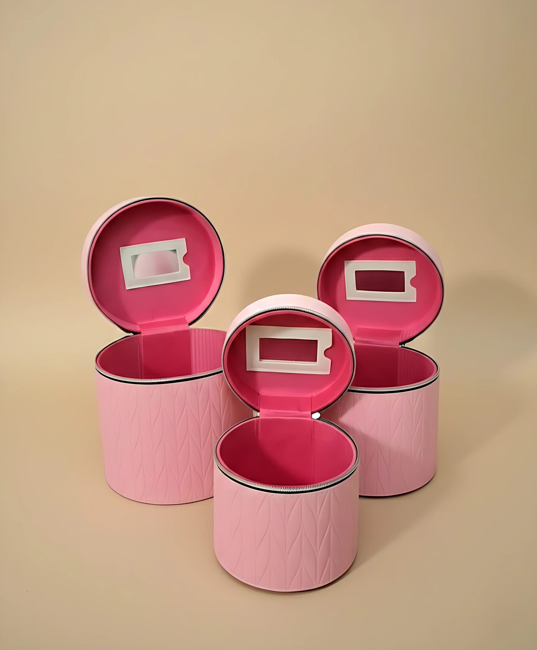 Set de tres neceseres circulares en rosa con textura de diamante, tapas abiertas mostrando espejo integrado y borde negro.