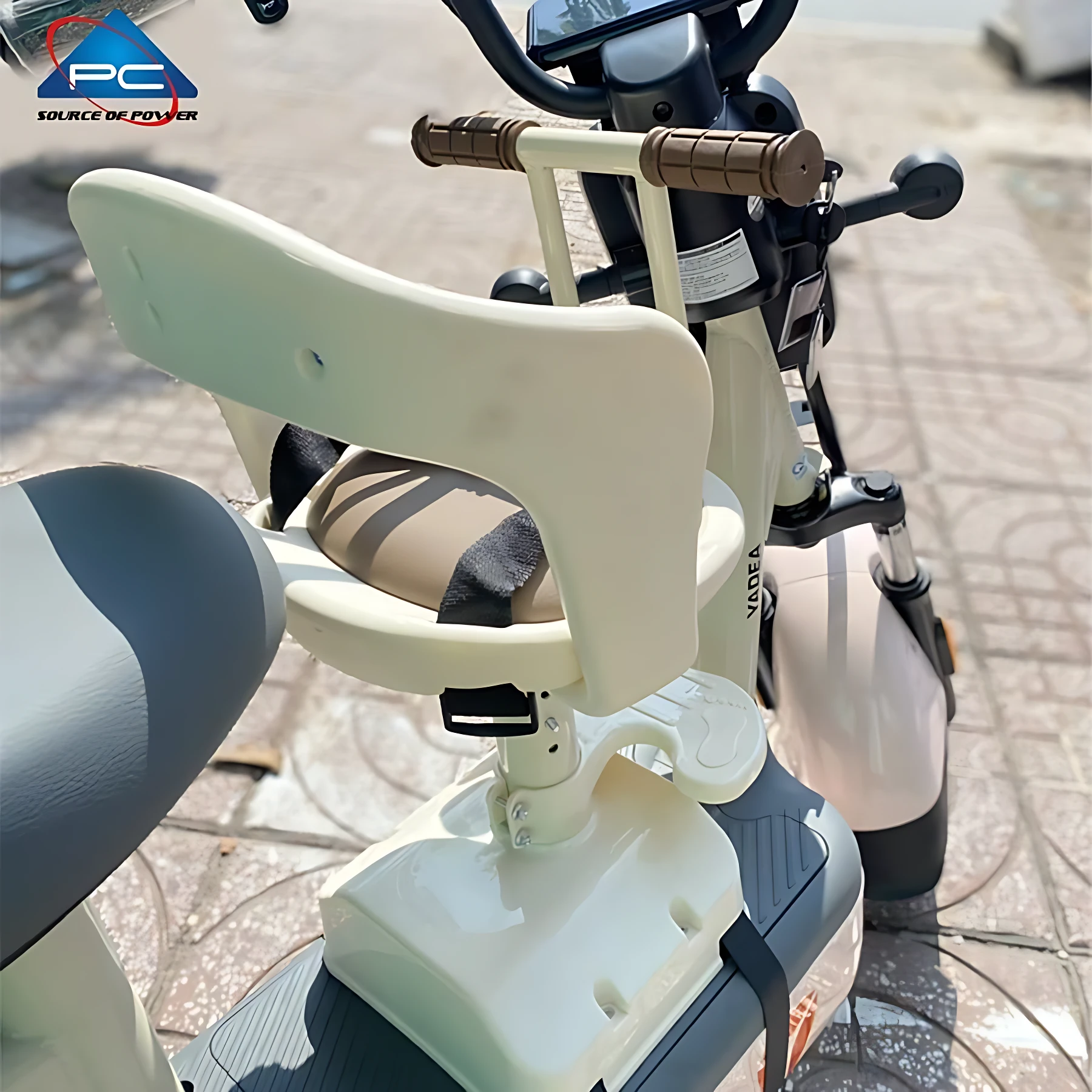 Silla infantil delantera para scooter en color crema, con respaldo ergonómico, asiento acolchado y arnés de seguridad ajustable. Instalada sobre el manillar, permite al niño viajar frente al conductor con visibilidad directa.