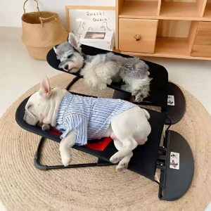Silla mecedora para perros en color negro, con dos ejemplares durmiendo: uno blanco con camisa azul y otro gris. Incluye cinturón de seguridad y reposacabezas ajustable.