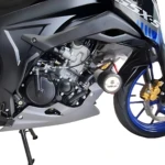 Vista lateral de la moto Suzuki GSX-S 150 en color negro con detalles azules, mostrando el motor, rueda delantera con pinza dorada y soporte de pie. Incluye protección lateral en acero inoxidable.