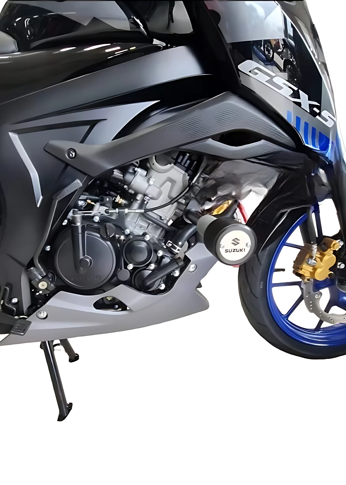 Vista lateral de la moto Suzuki GSX-S 150 en color negro con detalles azules, mostrando el motor, rueda delantera con pinza dorada y soporte de pie. Incluye protección lateral en acero inoxidable.