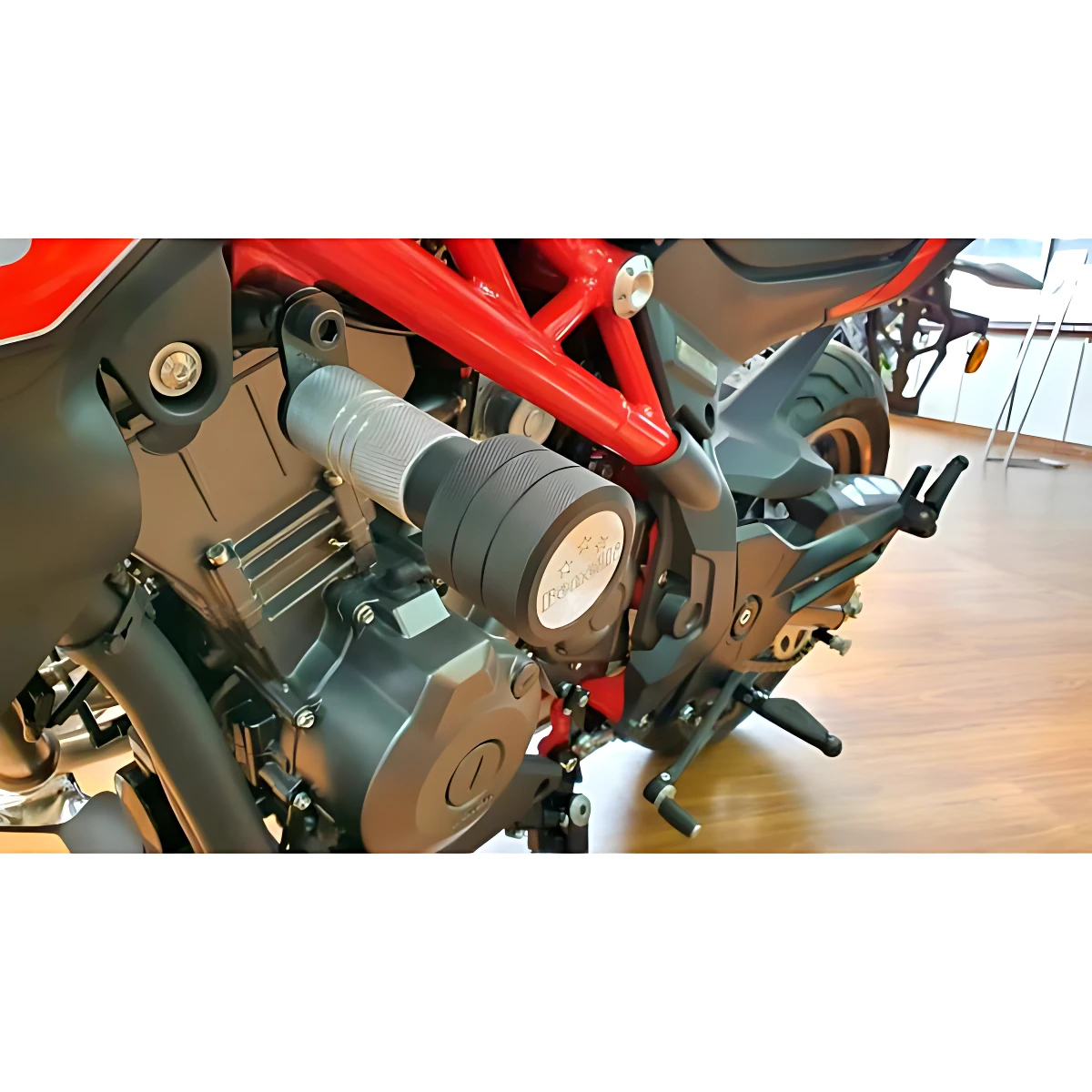 Slider de lujo Benelli 302 en acero inoxidable, montado en chasis rojo, protege contra impactos y rasguños diarios.