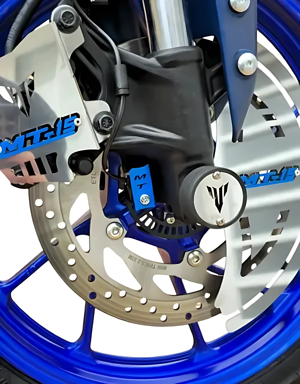 Sliders Spool MT 15 de acero inoxidable en azul, montados en horquilla delantera de motocicleta, con logotipo visible y protección contra impactos.