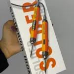Soldador portátil Sk-1 en caja blanca con letras naranjas, mostrando dos puntas intercambiables y cable negro; incluye estano.