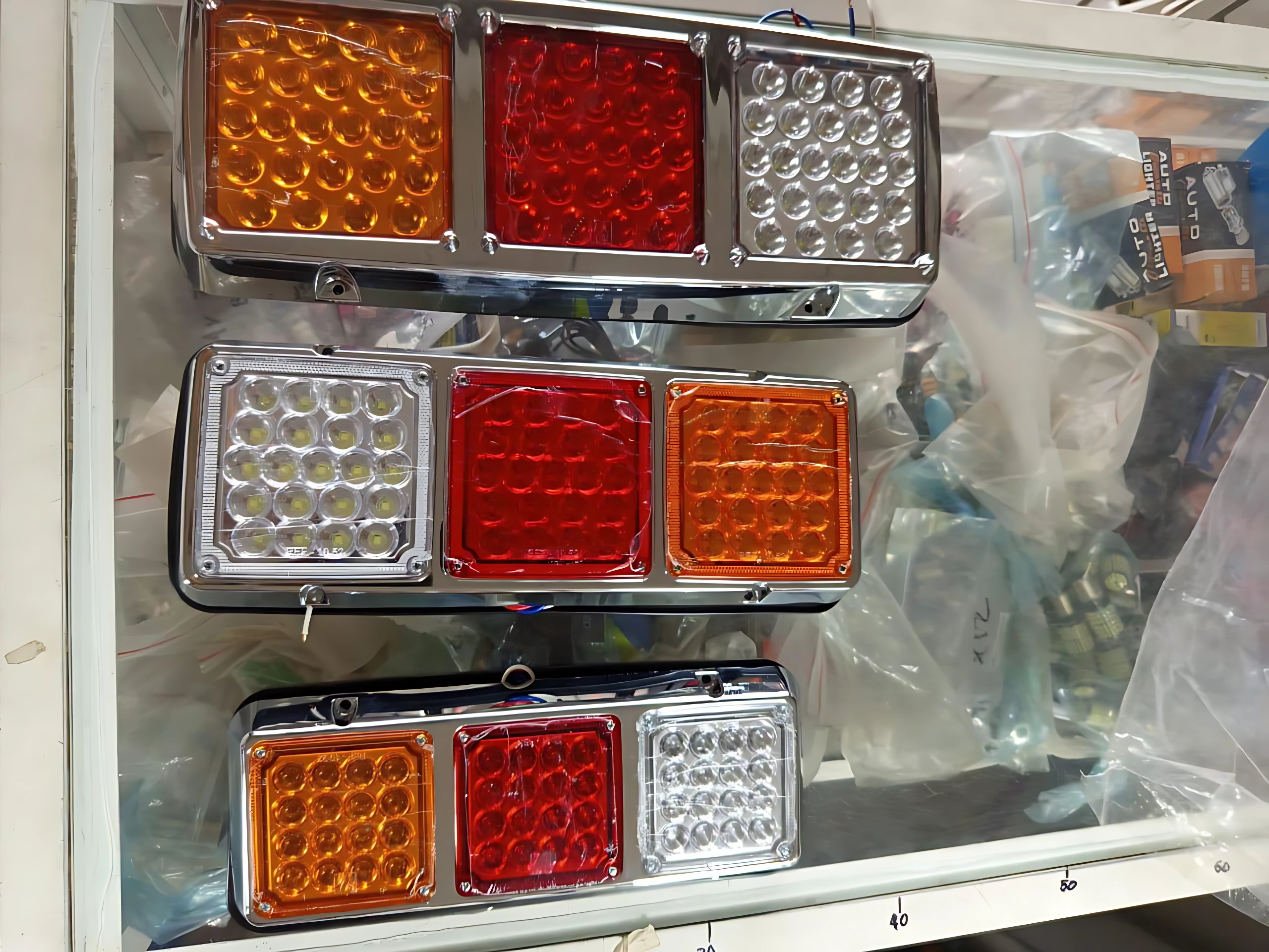 Tres luces stop LED pequeñas en colores ámbar, rojo y blanco, montadas en marco metálico, ideales para camiones y turbinas.