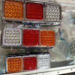Tres luces de stop pequeñas en LED para camiones y turbinas, con tres módulos: ámbar, rojo y blanco, montadas en chasis metálico.