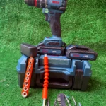 Taladro inalámbrico 12V Bosch de litio con reversibilidad, color azul y negro, sobre base de carga con accesorios incluidos: brocas, llave de impacto y batería.