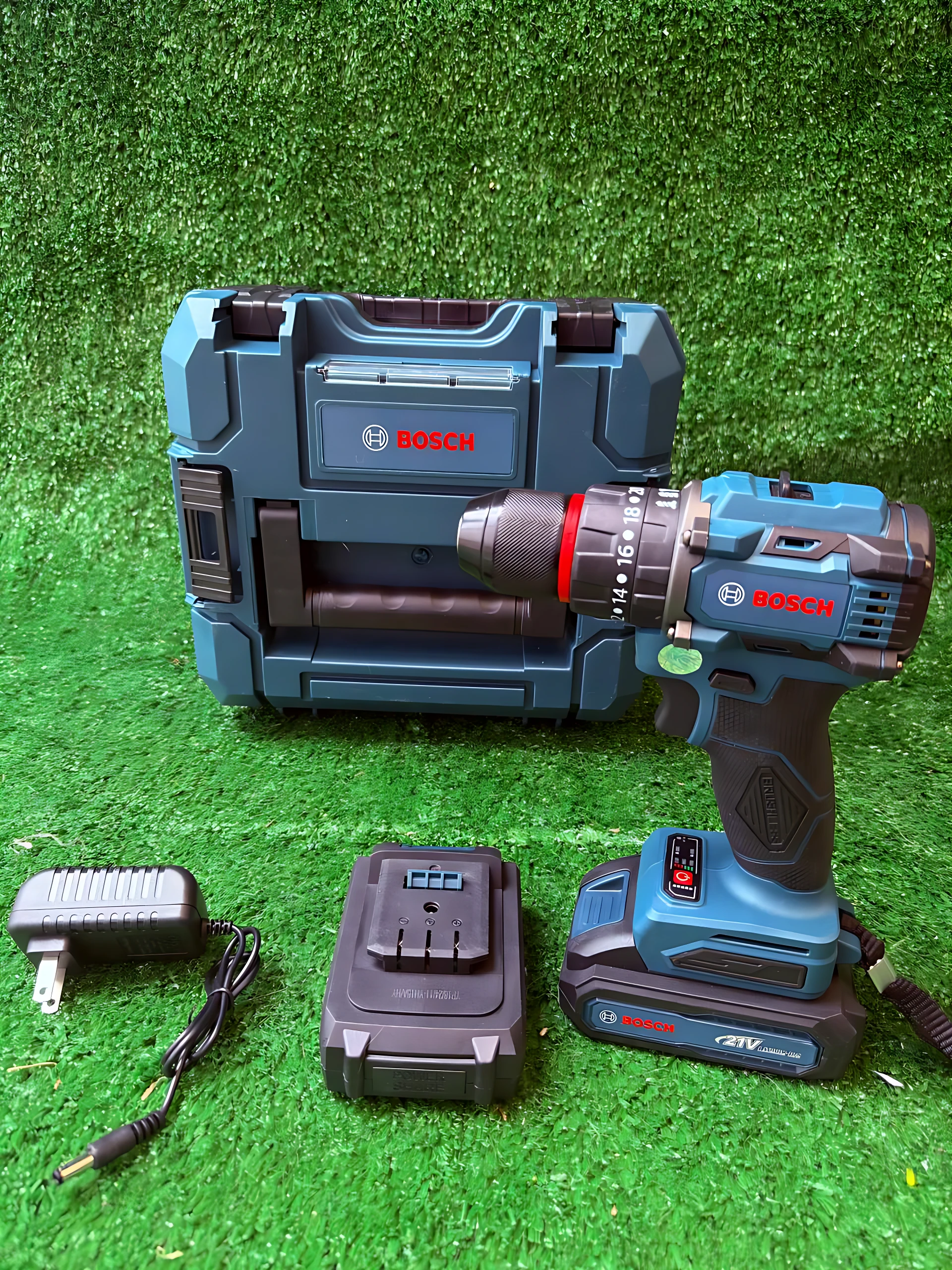 Taladro inalámbrico Bosch de 12V en color azul con caja de transporte, cargador y batería incluidos sobre fondo verde.