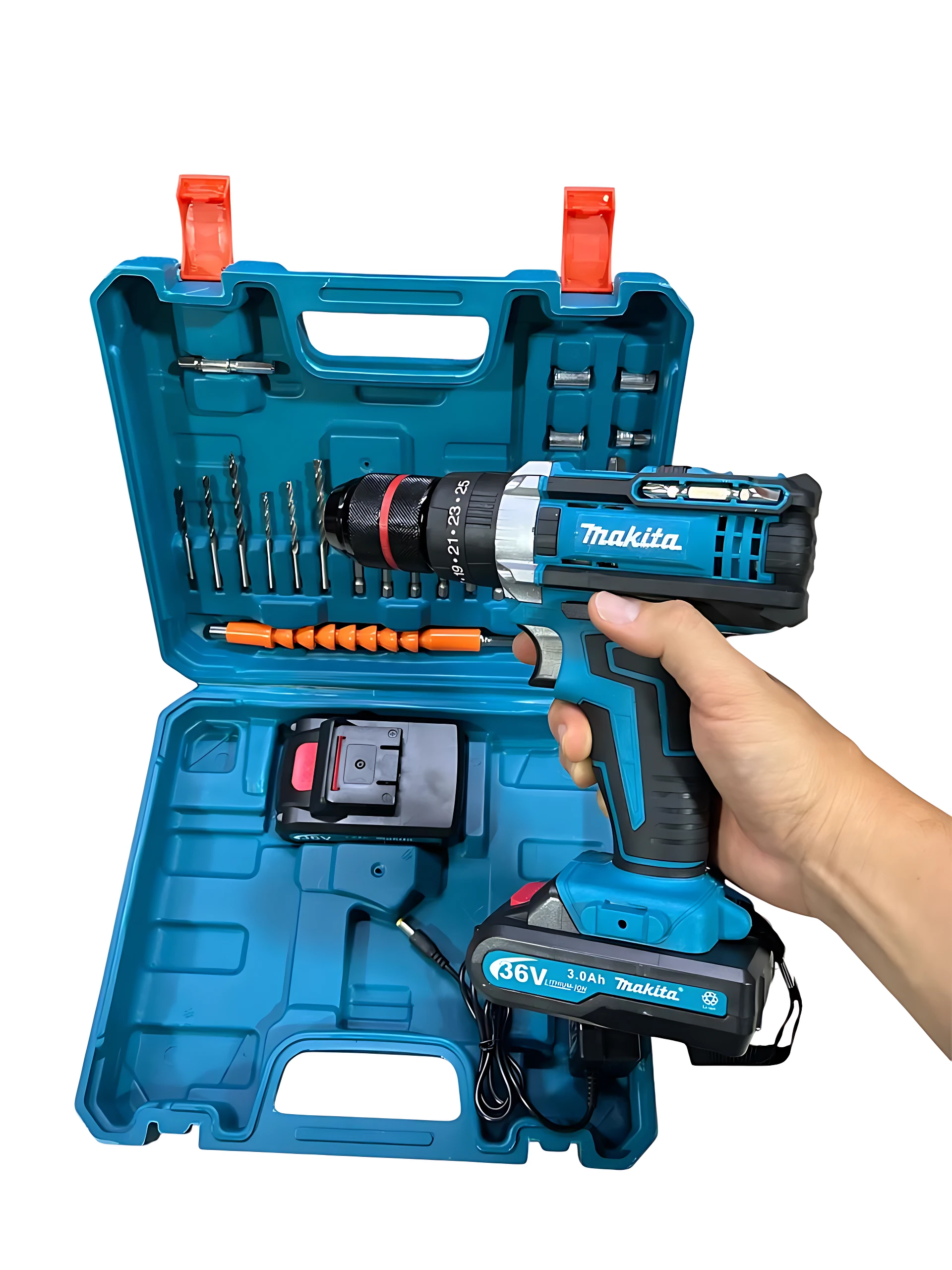 Taladro inalámbrico Makita 36V en caja azul abierta, con accesorios incluidos: brocas, taladro de madera y batería. Mano sosteniendo el equipo.