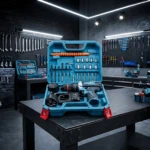 Taladro percutor Makita 24V sin cable en caja azul abierta, mostrando brocas, accesorios y batería sobre mesa de trabajo en taller con herramientas colgadas en pared oscura.