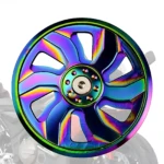 Tapa magneto rotor NKD con acabado iridiscente multicolor, vista frontal mostrando diseño de radios y centro con tornillos.