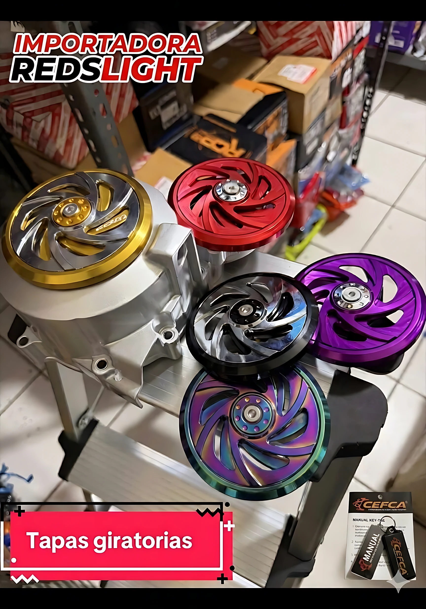 Tapa volante giratorio de aluminio anodizado en colores dorado, rojo, negro, morado y multicolor, montada sobre estructura metálica, ideal para personalizar scooters.