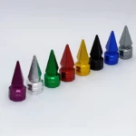 Set de tres tapas de válvula tipo spike en aluminio, disponibles en colores negro, azul, rojo, verde, amarillo, plateado y morado, con acabado brillante y diseño puntiagudo para estética agresiva.