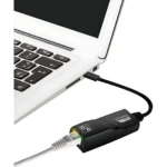 Adaptador USB C a Ethernet negro, conectado a laptop blanca, con cable de red visible y luz verde encendida en el puerto.