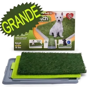 Tapete de entrenamiento para perro grande con césped real, en caja verde y blanco, mostrando perrito blanco y negro. Incluye base gris y capa superior verde con textura de pasto. Etiqueta indica “Grande” y “hasta 15 kg”.