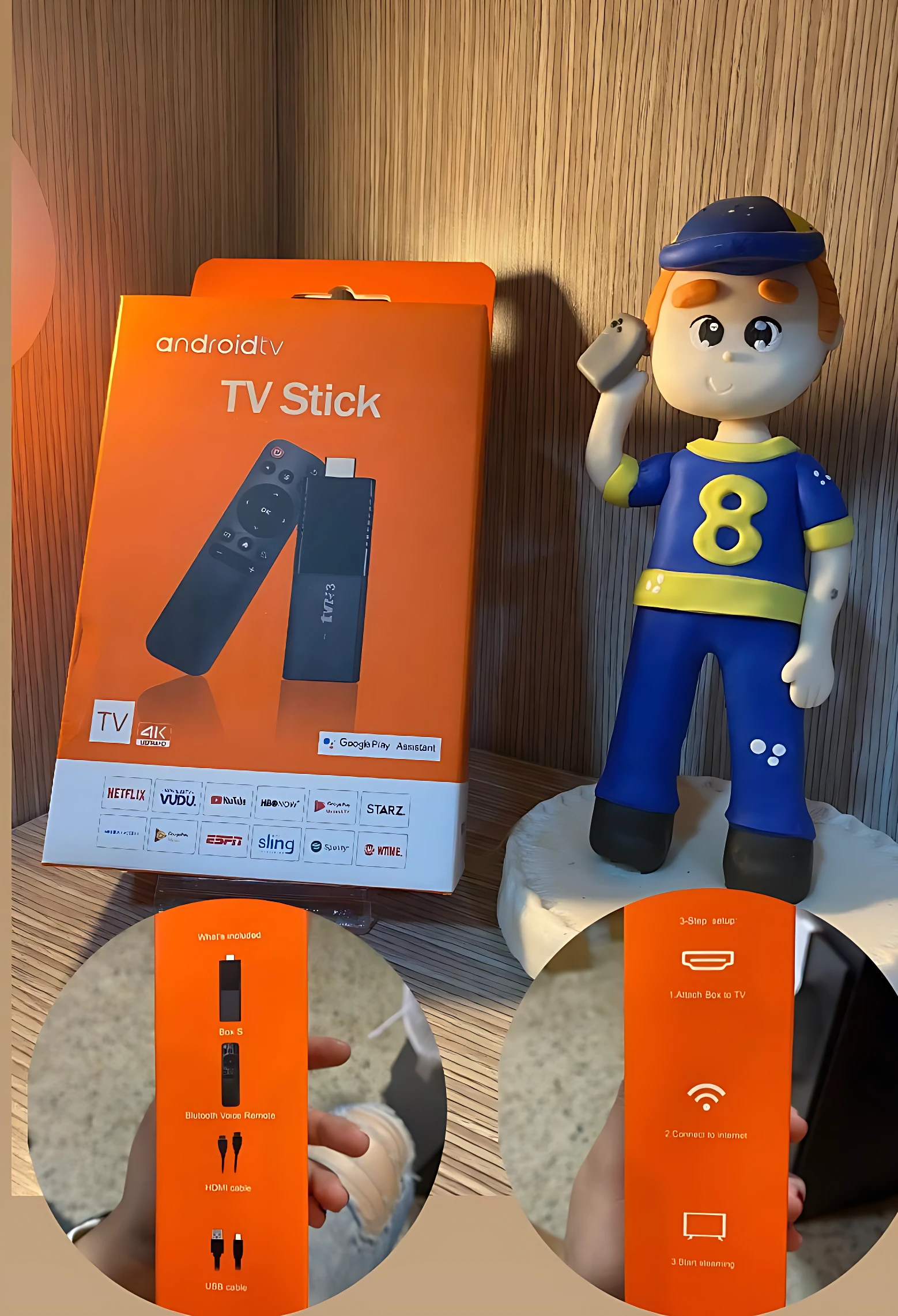 Caja naranja del adaptador Android TV Stick de 8GB, mostrando control remoto y detalles de conectividad, acompañado de figura decorativa infantil.