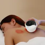 Masajeador V-90 blanco con pantalla digital y luz roja, aplicando succión en hombro de persona recostada.
