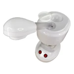 Vaporizador facial blanco con boquilla de masaje y dos luces rojas en base, sobre fondo blanco.