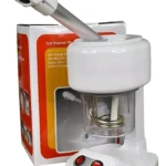 Vaporizador facial blanco con mango ergonómico y base de control, junto a su caja de cartón con diseño naranja y texto informativo.