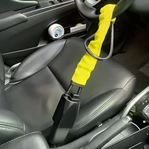 Volante Seguro Pro con bloqueo físico: funda amarilla con cable metálico enrollado, instalado en volante de auto negro, visiblemente bloqueado para disuadir robos.